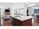Kitchen island with stainless sink overlooking the Gathering room with stone fireplace and ample windows at 4421 Wooded Oaks Nw, Kennesaw, GA 30152