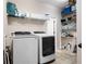 Efficient laundry room featuring modern washer and dryer, shelving, and storage solutions at 4421 Wooded Oaks Nw, Kennesaw, GA 30152