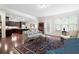 Open-concept living room with hardwood floors, a comfortable sofa, and seamless access to the kitchen area at 4421 Wooded Oaks Nw, Kennesaw, GA 30152