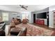Comfortable living room featuring hardwood floors, plush seating, a ceiling fan, and large windows for natural light at 4421 Wooded Oaks Nw, Kennesaw, GA 30152