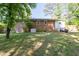 Large backyard with mature trees and brick home visible, offering plenty of room for recreation at 573 Lyle Se Dr, Marietta, GA 30067