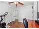 Bedroom featuring wood floors, a ceiling fan, desk, a large closet, and stationary exercise equipment at 573 Lyle Se Dr, Marietta, GA 30067
