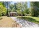 Charming brick home features a long driveway, lush lawn, and mature trees, offering a serene setting at 573 Lyle Se Dr, Marietta, GA 30067