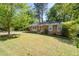 Traditional brick home features a well-manicured lawn and mature trees, creating a welcoming entrance at 573 Lyle Se Dr, Marietta, GA 30067