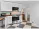 Stylish kitchen showcasing white cabinets, stainless appliances, and striking black and white checkered flooring at 573 Lyle Se Dr, Marietta, GA 30067