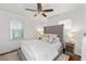 Cozy main bedroom with a tufted headboard, ceiling fan, and hardwood floors with area rug at 573 Lyle Se Dr, Marietta, GA 30067