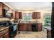 Traditional kitchen featuring brown cabinetry, laminate countertops, and black appliances at 258 Cristy Dr, Dallas, GA 30157