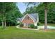 Side view of a brick home with a lush green lawn and tree coverage at 3570 Bulloch Lake Rd, Loganville, GA 30052