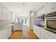 Modern kitchen with white cabinets, stainless steel appliances, and hardwood floors at 3570 Bulloch Lake Rd, Loganville, GA 30052