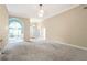 Open-concept living room with neutral walls, plush carpet and elegant lighting fixtures at 3570 Bulloch Lake Rd, Loganville, GA 30052