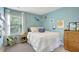 Light blue bedroom featuring a full sized bed, colorful artwork and a window seat at 4974 Whiteoak Walk Se # 21, Smyrna, GA 30080