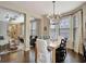 Light-filled dining room with wood floors, modern chandelier, and view into the living room at 4974 Whiteoak Walk Se # 21, Smyrna, GA 30080