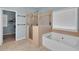 Bathroom featuring a glass shower and a soaking tub with a tile surround at 52 Weatherstone Way, Dallas, GA 30157