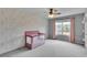 Bright bedroom with a floral accent wall, ceiling fan, and window that provides natural light at 52 Weatherstone Way, Dallas, GA 30157