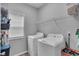 Bright laundry room with washer, dryer and shelf storage for organization at 52 Weatherstone Way, Dallas, GA 30157