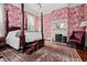 Spacious bedroom featuring a four-poster bed, decorative fireplace, and floral wallpaper at 285 Kennesaw Nw Ave, Marietta, GA 30060