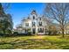 A grand, white Victorian home with a tower, black shutters, and a spacious green lawn in the front yard at 285 Kennesaw Nw Ave, Marietta, GA 30060