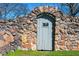 Charming stone wall with archway and rustic wooden door feature, perfect for a garden or secluded space at 285 Kennesaw Nw Ave, Marietta, GA 30060