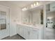 Bright bathroom with double sinks, white cabinets, and a large mirror with vanity lighting at 3420 Reagan Way, Lawrenceville, GA 30044
