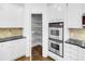 Well-organized pantry and stainless double oven in a bright kitchen with dark countertops at 4428 Wilkerson Manor Se Dr # 6, Smyrna, GA 30080