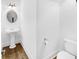 Cozy powder room with a pedestal sink, stylish oval mirror, and hardwood floors at 4428 Wilkerson Manor Se Dr # 6, Smyrna, GA 30080