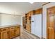 Kitchen area with wood cabinets, granite countertops, white refrigerator, and dining area at 452 Hightower Ridge Rd, Covington, GA 30014