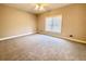Spacious bedroom with neutral walls and carpet, bathed in natural light from a large window at 512 Clearwater Dr, Mcdonough, GA 30252