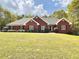 Beautifully landscaped red brick home with a well-manicured lawn and lush trees at 512 Clearwater Dr, Mcdonough, GA 30252