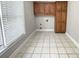 Spacious laundry room with tile flooring, storage cabinets, and natural light from the window at 512 Clearwater Dr, Mcdonough, GA 30252
