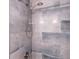 Shower has a rainfall shower head and is tiled in light blue stone-look tiles at 6851 Roswell Rd # A-12, Atlanta, GA 30328
