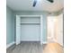 Bright bedroom features an open closet with wood flooring and neutral colored walls at 6851 Roswell Rd # A-12, Atlanta, GA 30328