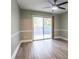Bright bedroom featuring a ceiling fan, sliding glass door to a small fenced yard, and laminate floors at 6851 Roswell Rd # A-12, Atlanta, GA 30328