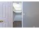 Open view into walk-in closet with white shelving, neutral color walls, and wood flooring at 6851 Roswell Rd # A-12, Atlanta, GA 30328
