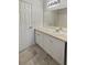 Clean bathroom featuring a tile floor, a single sink vanity with white cabinets, and a framed mirror at 7747 Rountree Xing, Riverdale, GA 30274