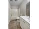 Bright bathroom features a shower-tub combo and a single sink vanity with white cabinets and gray tile flooring at 7747 Rountree Xing, Riverdale, GA 30274