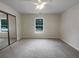 Spacious bedroom features plush carpeting, a ceiling fan and a mirrored closet and a window at 7747 Rountree Xing, Riverdale, GA 30274