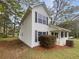 Two-story home has a cozy front porch, black window shutters and beautiful mature trees at 7747 Rountree Xing, Riverdale, GA 30274