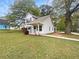 Charming two-story home featuring a cozy front porch, a well-maintained lawn, mature trees, and manicured shrubbery at 7747 Rountree Xing, Riverdale, GA 30274