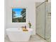Luxurious bathroom featuring a freestanding tub, marble-tiled shower, gold fixtures, and a large window at 1598 Athens Ave, Atlanta, GA 30310