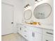 Bathroom with double sinks, white cabinets with black hardware, marble countertops, and round mirrors at 1598 Athens Ave, Atlanta, GA 30310