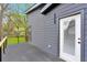 Back of house featuring gray siding, black trim, white door, and a deck overlooking the backyard at 1598 Athens Ave, Atlanta, GA 30310