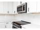 Close-up of a kitchen with a modern microwave and stovetop, complemented by white subway tiles at 2721 Creek View Nw Ter, Atlanta, GA 30318