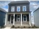 Charming two-story home featuring dark siding, white trim, a welcoming front porch, and beautiful landscaping at 2725 Creek View Nw Ter, Atlanta, GA 30318