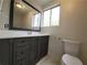 Well-lit bathroom features gray vanity, sleek fixtures, a framed mirror, and crisp white walls at 336 Sir Richard Ct, Jonesboro, GA 30236