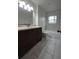 Well-lit bathroom with a dark vanity, ample counter space, a tub, and marble-style tile for a clean aesthetic at 336 Sir Richard Ct, Jonesboro, GA 30236