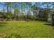 Spacious back yard featuring a large lawn, mature trees, and a wooden fence surrounding the perimeter at 545 Bellemeade Sw Dr, Marietta, GA 30008