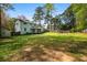 Spacious backyard with large lawn area, mature trees, storage shed, and a screened porch ideal for outdoor activities at 545 Bellemeade Sw Dr, Marietta, GA 30008