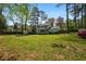Expansive backyard featuring lush lawn, mature trees, and a charming screened porch, perfect for outdoor relaxation at 545 Bellemeade Sw Dr, Marietta, GA 30008