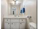 This bathroom includes a single sink vanity, white cabinets, bright lighting, and well-placed towel rack at 545 Bellemeade Sw Dr, Marietta, GA 30008