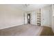 Bedroom with neutral walls and carpet flooring featuring a closet, built-in shelves, and doorway to the hallway at 545 Bellemeade Sw Dr, Marietta, GA 30008